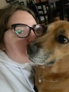 A woman with glasses and a dog