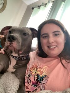 A woman and her dog are smiling for the camera.