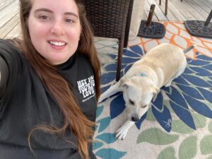 A woman and her dog are sitting on the floor.