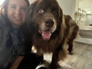 A woman and her dog are smiling for the camera.