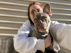 A person holding a dog in their arms.